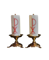 Candelero de mesa con motivos litúrgicos en la base con vela